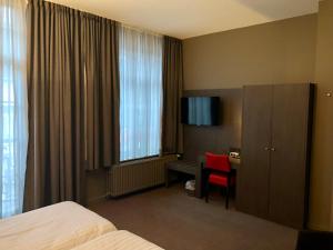 迪斯特德珐昂斯克朗酒店的配有一张床、一张书桌和一扇窗户的酒店客房