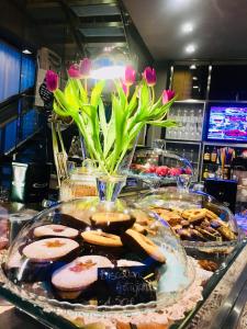 博尔格弗索吉亚伊曾尼美景及咖啡公寓式酒店的粉红色花的柜台上展示饼干和糕点