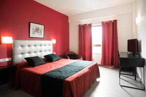 圣佩佩图阿-德莫古达西姆瓦勒斯酒店的红色卧室配有床和电视