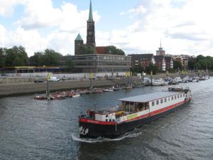阿姆斯特丹Hotelboat Angeline的一条在城市里沿着河流航行的船
