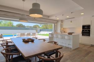 卡莱利亚德帕拉弗鲁赫尔Modern Villa Olivera with Private Pool的厨房以及带桌椅的用餐室。