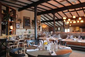 霍姆弗斯The Huntsman Inn的配有木桌、桌椅的餐厅
