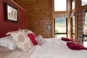 胡若胡若奥斯特里亚旅馆的卧室配有白色床和红色及白色枕头