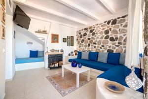 卡马利Moschatos Beach House的客厅设有蓝色的沙发和石墙