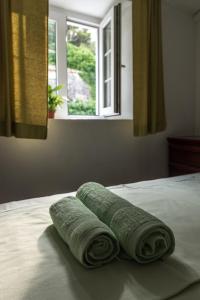 特雷斯塔尼克Apartment Matijas的三条滚毛巾坐在带窗户的床上