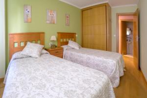 里瓦德塞利亚Apartamento Sella y Mar - VUT12AS的一间带两张床的卧室和一间浴室