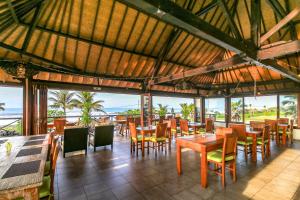 普卢坎Arton Resort & Beach Club的一间带桌椅的海景餐厅