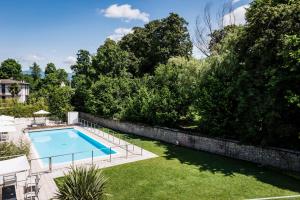 龙格甜蜜酒店的一座游泳池,位于一个修剪墙壁旁的院子内