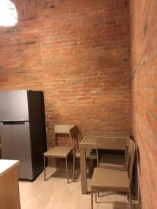 博尔若米Inka home的厨房配有桌椅和冰箱。