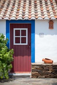 米尔芳提斯城Monte dos Parvos的屋顶有瓷砖的房子上的红色门