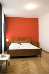 布拉格艾卡特罗安杰利酒店的一间卧室设有一张红色墙壁的大床