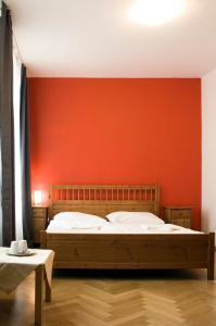 布拉格艾卡特罗安杰利酒店的一间卧室配有一张橙色墙壁的床