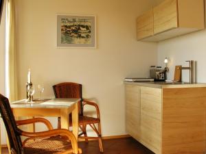 GriebenHotel Enddorn Appartement的厨房配有桌子、两把椅子和台面