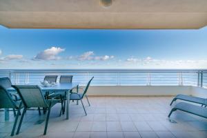 斯利马斯利马海滨公寓的一个带桌椅的海景阳台