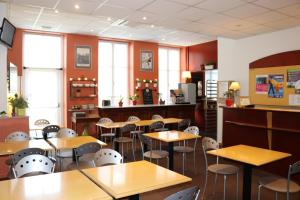 泰昂维Logis-Hôtel des Oliviers的餐厅里带桌椅的教室