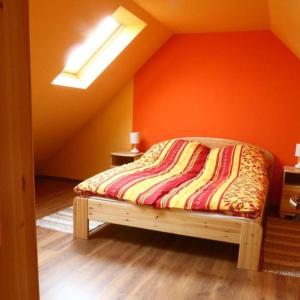 TiszabábolnaTiszavirág Vendégház的橙色墙壁间的一张床位