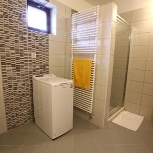 TiszabábolnaTiszavirág Vendégház的浴室设有卫生间和带黄毛巾的淋浴。