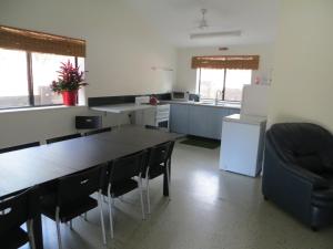 弗雷泽岛弗雷泽永远兰花海滩弗雷泽岛度假屋的厨房配有桌椅和冰箱。