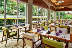 新加坡Treetops Executive Residences的餐厅设有桌椅和窗户。