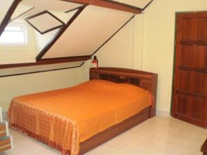 卡伦海滩普吉岛绿色家园旅馆的一间卧室配有一张带橙色床罩的床
