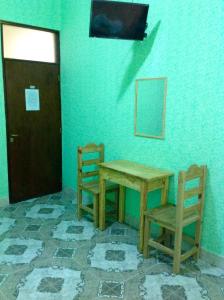 卡奇Hostería Don Arturo的一张桌子和两把椅子,放在一个有门的房间