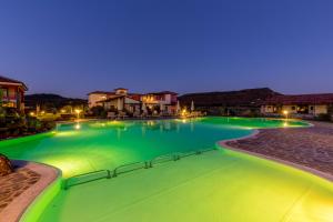 阿尔盖罗萨科雅雷拉伊斯水疗酒店的夜间带绿灯的大型游泳池