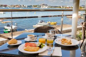 塔拉曼卡Hotel Simbad Ibiza的一张桌子,上面放有食物和饮料,享有水景