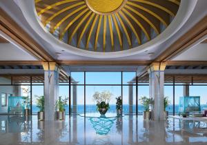拉卡尼亚泰拉索温泉度假&中庭名誉别墅酒店的大堂设有大型天花板和玻璃窗。