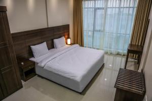 SamhānBarka Hotel Apartment的卧室设有一张白色大床和一扇窗户。