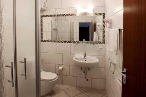 伊瑟隆Hotel Peiler Garni的一间带水槽、卫生间和镜子的浴室