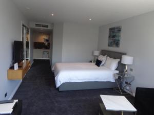 墨尔本码头西建筑私人一室公寓的酒店客房,配有床和电视