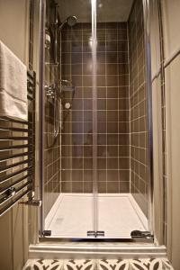 温德米尔避风港酒店的浴室里设有玻璃门淋浴