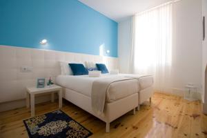 波尔图特瑞斯达迪住宿加早餐旅馆的卧室配有白色的床和蓝色的墙壁