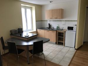 Saint-Didier-en-Velay维雷港度假屋的小厨房配有桌子和桌椅