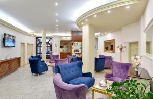 玛丽亚温泉大洲酒店的一间设有紫色椅子和一张桌子的等候室