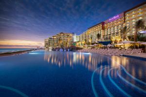 坎昆Hard Rock Hotel Cancun - All Inclusive的海滩前的酒店游泳池