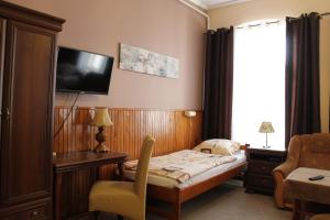 纳梅斯武夫珀洛尼亚酒店的酒店客房设有一张床和墙上的电视