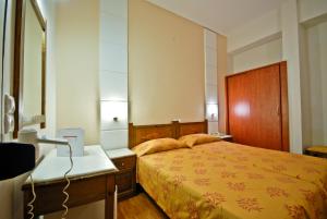 纳克索乔拉卡洛尼斯酒店的一间卧室配有一张床、梳妆台和镜子