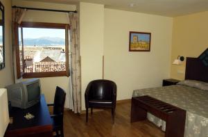 塞哥维亚穆德哈尔之家水疗酒店的一间卧室配有一张床、一台电视和一个窗口