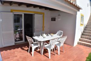吉亚Villa Amendoeira-POOL HEATED的庭院里的白色桌椅