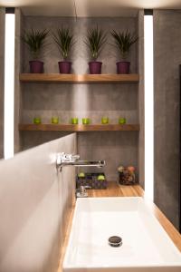 雅典BRAND NEW 2018 LUXURY APARTMENT 10' MINUTES WALK FROM ACROPOLIS AND 6 FROM METRO的浴室内有盆栽植物,设有白色水槽