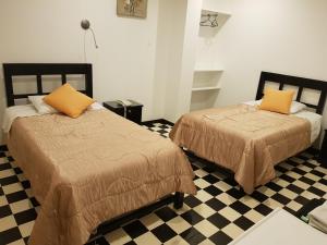 塔克纳Hostal Le Prince的一张位于带 ⁇ 形地板的客房内的两张床