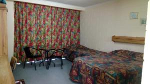埃尔利海滩群岛汽车旅馆的配有一张床和一张桌子及椅子的房间