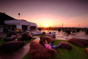 金巴兰金巴兰斯特萨酒店 的一群人在露台上躺着枕头,欣赏日落美景