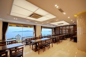 芽庄Lenid Ocean View Hotel的用餐室设有桌椅和窗户。