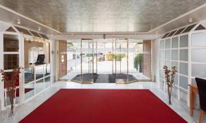 慕尼黑Living Hotel am Olympiapark的走廊上设有红地毯和玻璃门