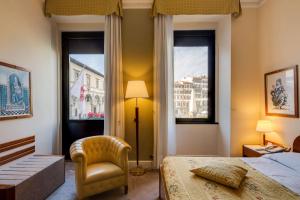 佛罗伦萨罗马酒店的一间卧室配有一张床和一把椅子,还有两个窗户