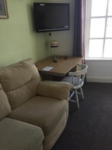 克莱克西顿Gateway Lodge的客厅配有沙发和带电视的桌子