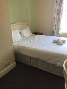 克莱克西顿Gateway Lodge的一张带白色床单和枕头的床