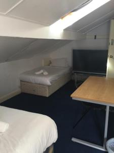 克莱克西顿Gateway Lodge的小房间设有两张床和一张书桌